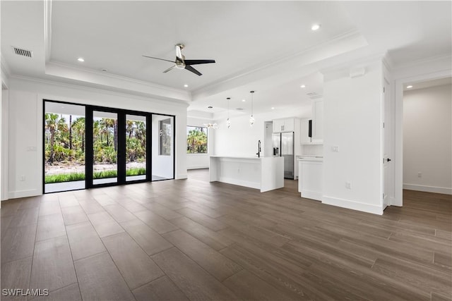 3473 14th Ave SE, Naples, FL 34117 - unfurnished living room with a tray ceiling, ceiling fan, dark wood-style flooring, recessed lighting, and crown molding