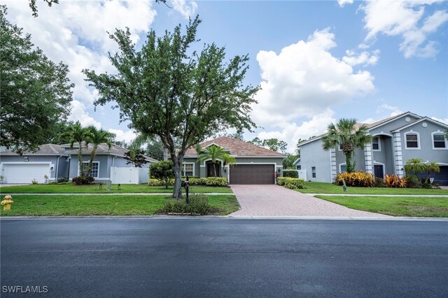 2759 Orange Grove Trl, Naples, FL 34120 - ranch-style house with driveway, an attached garage, and a front lawn