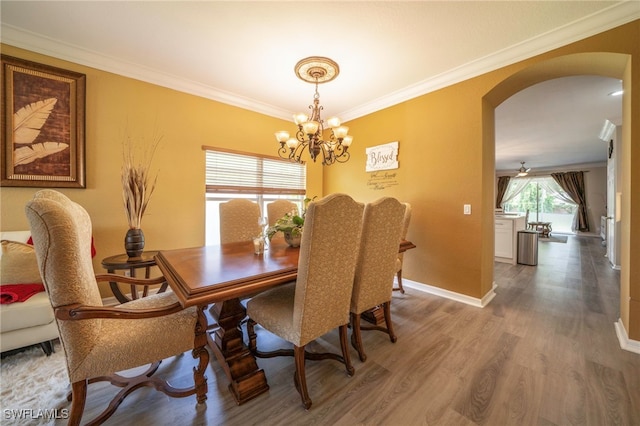 2759 Orange Grove Trl, Naples, FL 34120 - dining space with arched walkways, a chandelier, wood finished floors, crown molding, and baseboards
