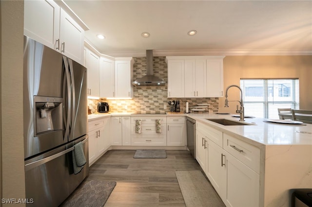 2759 Orange Grove Trl, Naples, FL 34120 - kitchen with stainless steel appliances, wall chimney range hood, a sink, a peninsula, and crown molding