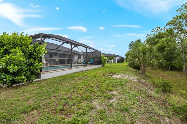 3901 NW 48th Ter, Cape Coral, FL 33993 - view of grassy yard with an outdoor pool and glass enclosure