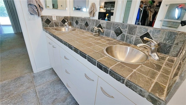 2780 39th St SW, Naples, FL 34117 - bathroom with double vanity, tasteful backsplash, a walk in closet, and tile patterned flooring