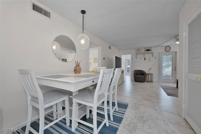 7400 College Pkwy Unit 61B, Fort Myers, FL 33907 - dining area with light marble finish flooring, a textured ceiling, and baseboards