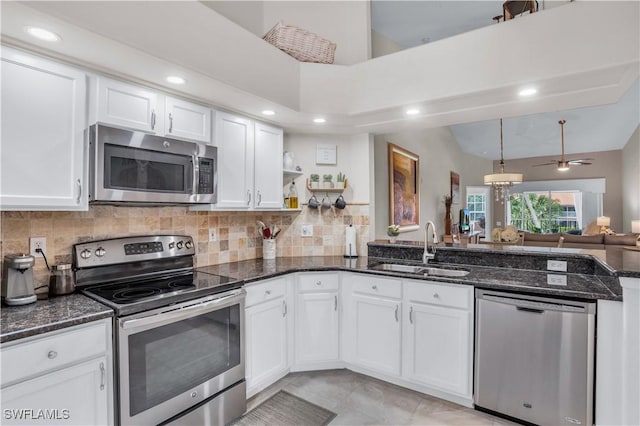 28076 Cavendish Ct Unit 2107, Bonita Springs, FL 34135 - kitchen with stainless steel appliances, a sink, white cabinetry, dark stone countertops, and tasteful backsplash