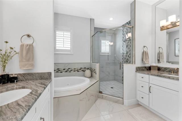 605 El Camino Real Unit 102, Naples, FL 34119 - bathroom with two vanities, a stall shower, and a garden tub