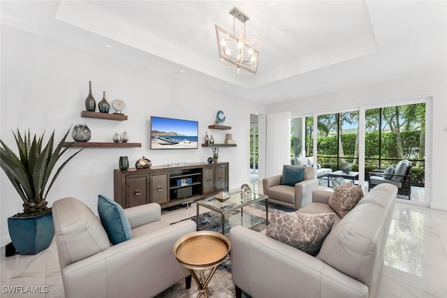 605 El Camino Real Unit 102, Naples, FL 34119 - living room with a raised ceiling, a chandelier, and baseboards
