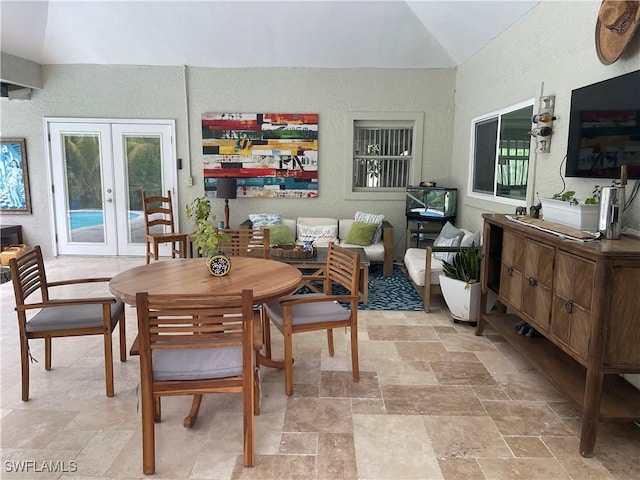 260 29th St SW, Naples, FL 34117 - dining room featuring french doors, a textured wall, light stone finish flooring, and vaulted ceiling
