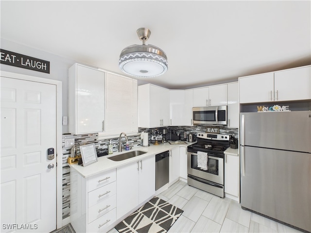 5600 Bonita Beach Rd Unit 201, Bonita Springs, FL 34134 - kitchen featuring stainless steel appliances, a sink, light countertops, white cabinets, and backsplash