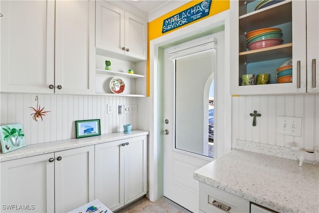 2839 Janet St, Matlacha, FL 33993 - kitchen with open shelves, arched walkways, white cabinets, and light stone countertops