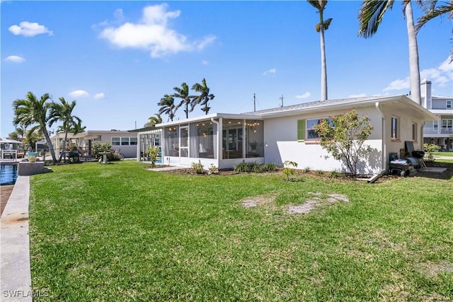 2839 Janet St, Matlacha, FL 33993 - back of house with a sunroom, a yard, and stucco siding