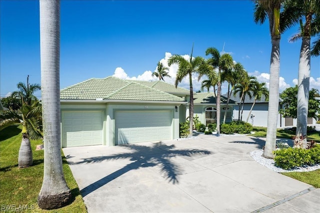 623 SW 56th St, Cape Coral, FL 33914 - view of front facade featuring a garage, driveway, a tile roof, and stucco siding