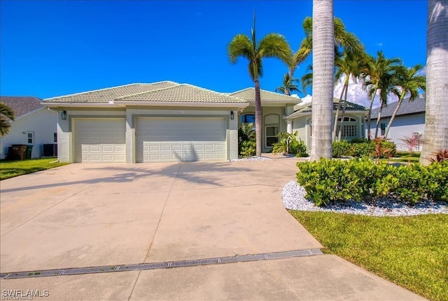 623 SW 56th St, Cape Coral, FL 33914 - view of front of house with concrete driveway, a garage, stucco siding, and a tiled roof