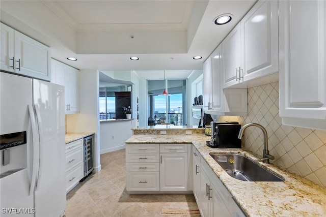 315 Dunes Blvd Unit 1006, Naples, FL 34110 - kitchen with white fridge with ice dispenser, a sink, beverage cooler, crown molding, and decorative backsplash