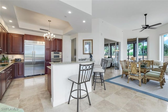 1050 Borghese Ln Unit 106, Naples, FL 34114 - kitchen with appliances with stainless steel finishes, a chandelier, recessed lighting, a kitchen bar, and a peninsula