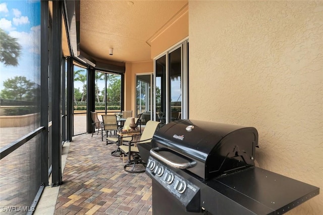 1050 Borghese Ln Unit 106, Naples, FL 34114 - sunroom featuring a textured wall, brick floors, and a textured ceiling