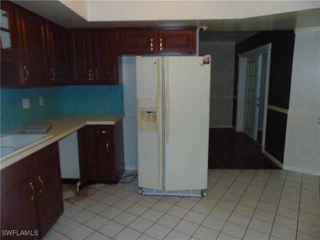 100 Waterview Ave, Lehigh Acres, FL 33936 - kitchen with white refrigerator with ice dispenser, light countertops, tasteful backsplash, light tile patterned floors, and a sink