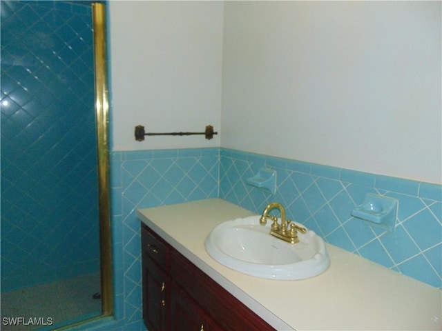 100 Waterview Ave, Lehigh Acres, FL 33936 - full bathroom featuring a stall shower, vanity, a wainscoted wall, and tile walls