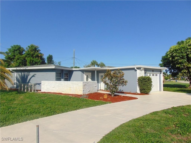 100 Waterview Ave, Lehigh Acres, FL 33936 - view of front facade featuring a garage, driveway, a front lawn, and stone siding