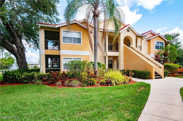 12580 Equestrian Cir Unit 1507, Fort Myers, FL 33907 - view of front of property with stucco siding, a front yard, and stairs