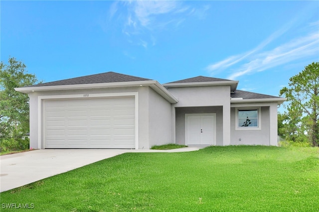 1072 Norton Ave S, Lehigh Acres, FL 33974 - prairie-style home featuring stucco siding, driveway, a front yard, and an attached garage