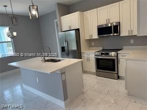 426 Mercedes Ct, Lehigh Acres, FL 33972 - kitchen with appliances with stainless steel finishes, a sink, pendant lighting, light marble finish flooring, and light countertops