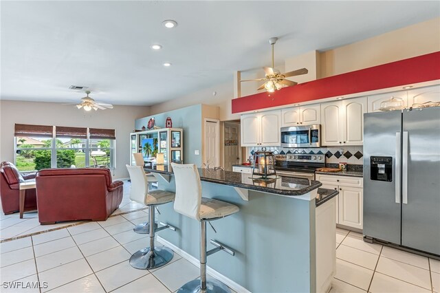 1927 SW 48th Ln, Cape Coral, FL 33914 - kitchen with stainless steel appliances, a ceiling fan, a kitchen breakfast bar, light tile patterned floors, and recessed lighting