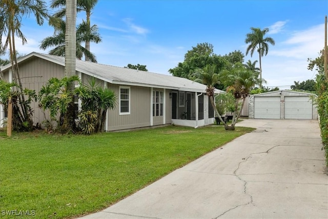 51-55 Lake St, North Fort Myers, FL 33903 - view of front of house with a detached garage, a sunroom, a front lawn, and an outbuilding