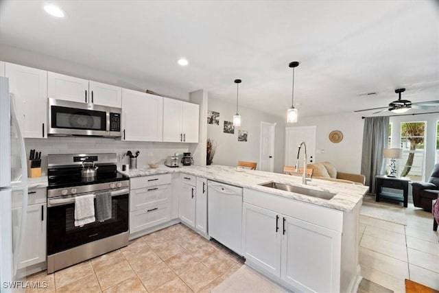 51-55 Lake St, North Fort Myers, FL 33903 - kitchen featuring appliances with stainless steel finishes, a sink, a peninsula, light tile patterned floors, and recessed lighting