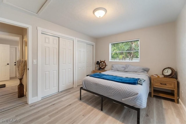 51-55 Lake St, North Fort Myers, FL 33903 - bedroom featuring multiple closets, light wood finished floors, baseboards, and attic access