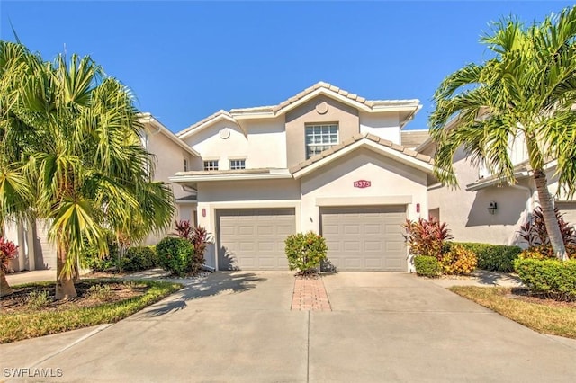8375 Whisper Trace Ln Unit M203, Naples, FL 34114 - mediterranean / spanish-style home featuring driveway, stucco siding, a garage, and a tiled roof