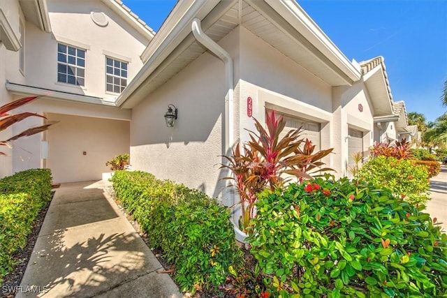 8375 Whisper Trace Ln Unit M203, Naples, FL 34114 - view of side of property with stucco siding and an attached garage