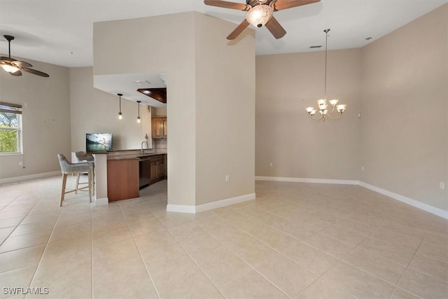 8375 Whisper Trace Ln Unit M203, Naples, FL 34114 - unfurnished living room featuring a ceiling fan, light tile patterned floors, a sink, a towering ceiling, and baseboards