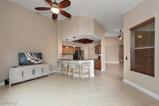 8375 Whisper Trace Ln Unit M203, Naples, FL 34114 - kitchen featuring stainless steel appliances, a ceiling fan, a peninsula, light tile patterned flooring, and a kitchen breakfast bar