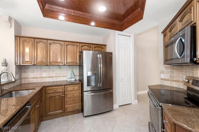 8375 Whisper Trace Ln Unit M203, Naples, FL 34114 - kitchen with stainless steel appliances, a sink, a tray ceiling, and dark stone counters