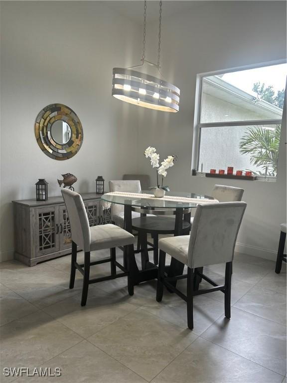 233 Baize Ave S, Lehigh Acres, FL 33974 - dining room featuring baseboards and a towering ceiling