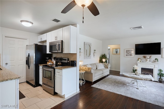 13219 2nd St, Fort Myers, FL 33905 - kitchen featuring stainless steel appliances, open floor plan, white cabinetry, and light stone counters