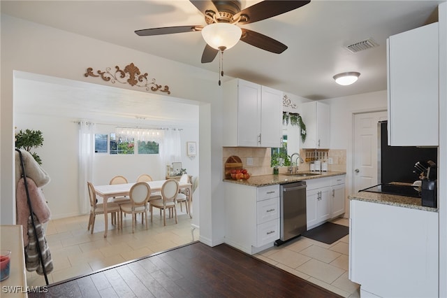 13219 2nd St, Fort Myers, FL 33905 - kitchen featuring stainless steel dishwasher, a sink, white cabinets, backsplash, and plenty of natural light