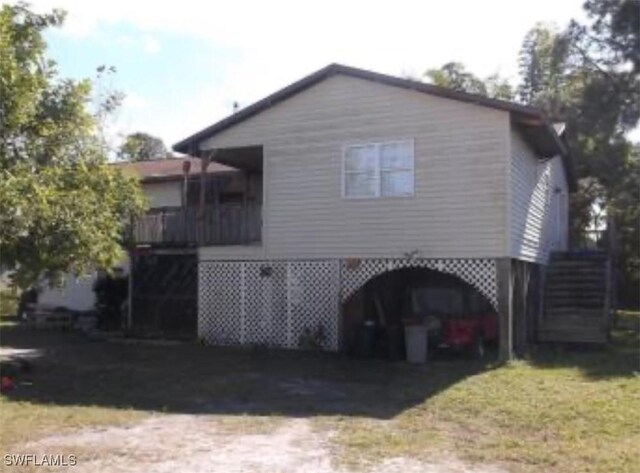 3411 22nd St SW, Lehigh Acres, FL 33976 - rear view of house featuring a carport, driveway, and stairway