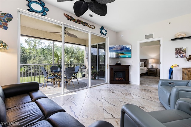 10530 Amiata Way Unit 201, Fort Myers, FL 33913 - living area featuring ceiling fan, a glass covered fireplace, and marble look tiles