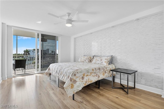 5 Bluebill Ave Unit 410, Naples, FL 34108 - bedroom with access to exterior, wood finished floors, a wall of windows, and ceiling fan