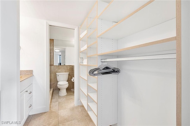 5 Bluebill Ave Unit 410, Naples, FL 34108 - bathroom with vanity, tile patterned flooring, and tile walls
