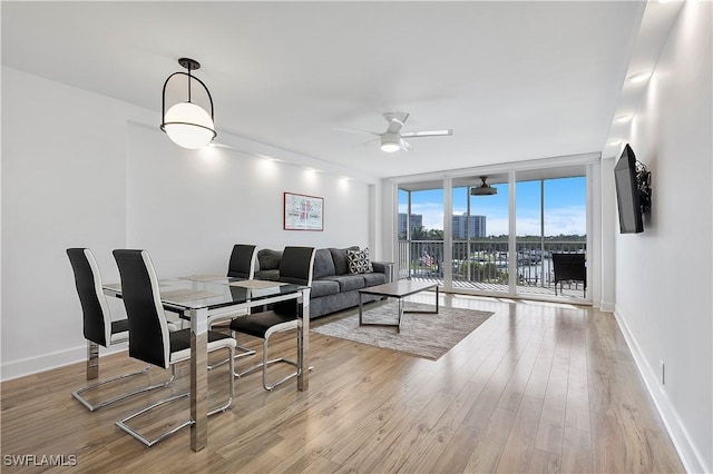 5 Bluebill Ave Unit 410, Naples, FL 34108 - living room with a wall of windows, a ceiling fan, and wood finished floors