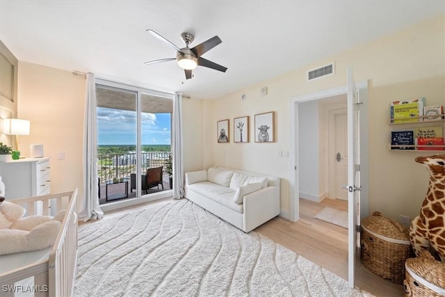 2104 W First St Unit 1402, Fort Myers, FL 33901 - living room with light wood-type flooring, a ceiling fan, and expansive windows