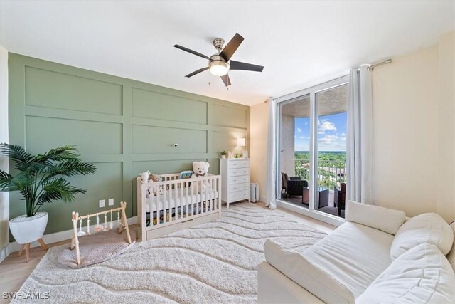 2104 W First St Unit 1402, Fort Myers, FL 33901 - bedroom featuring access to outside, ceiling fan, baseboards, light wood-style floors, and expansive windows