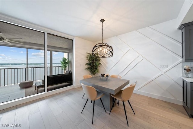 2104 W First St Unit 1402, Fort Myers, FL 33901 - dining room with a chandelier, light wood finished floors, a water view, ceiling fan, and baseboards