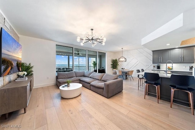 2104 W First St Unit 1402, Fort Myers, FL 33901 - living room with a chandelier, light wood finished floors, and baseboards