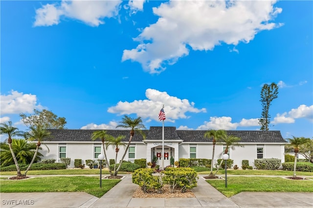 6843 Bogey Dr, Fort Myers, FL 33919 - view of front facade featuring a front lawn, mansard roof, and stucco siding