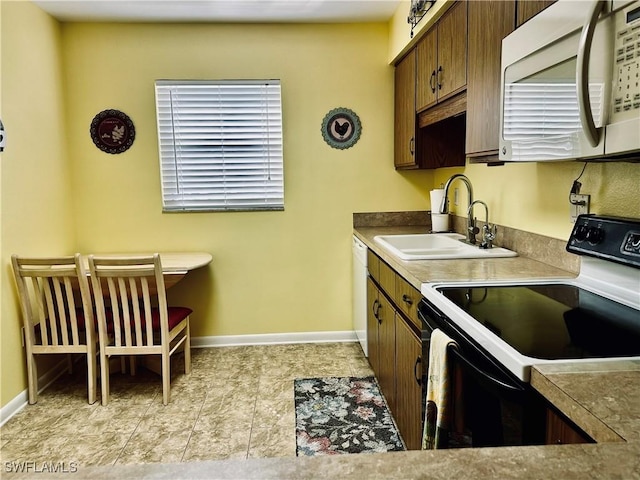 6843 Bogey Dr, Fort Myers, FL 33919 - kitchen with white appliances, a sink, and baseboards