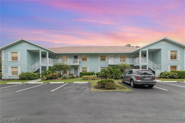 5737 Whitaker Rd Unit C203, Naples, FL 34112 - property at dusk featuring stairway and uncovered parking