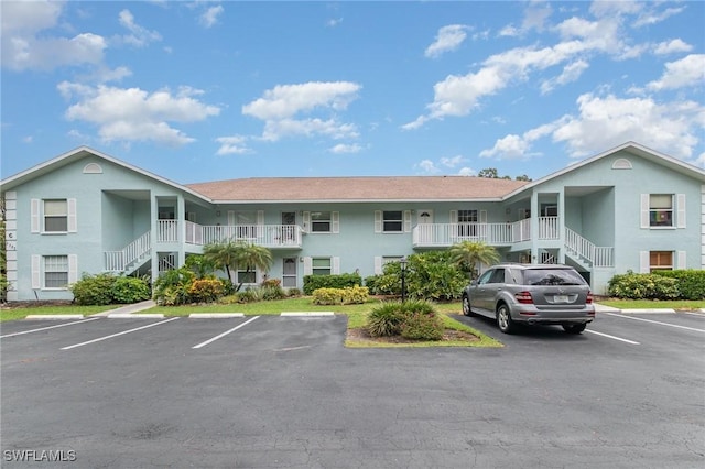 5737 Whitaker Rd Unit C203, Naples, FL 34112 - view of building exterior featuring stairs and uncovered parking